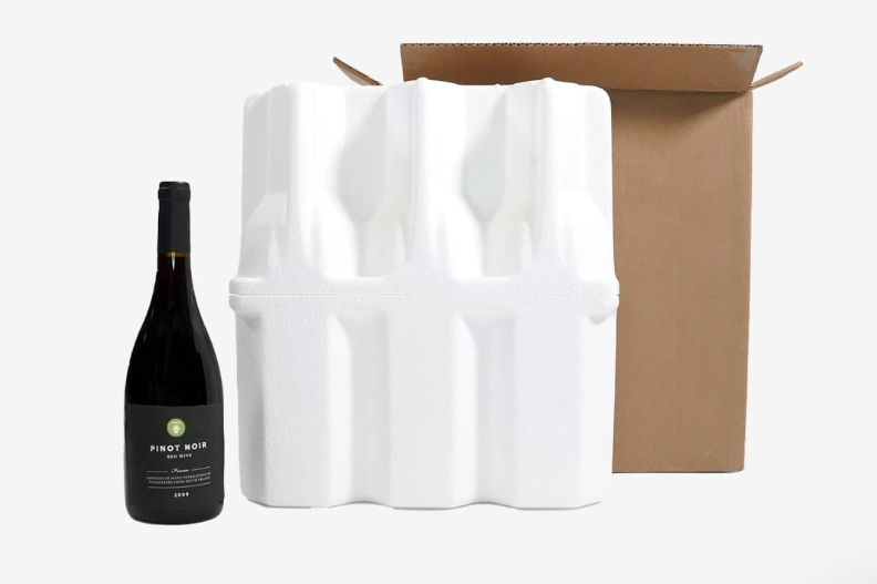 A black wine bottle next to styrofoam packaging