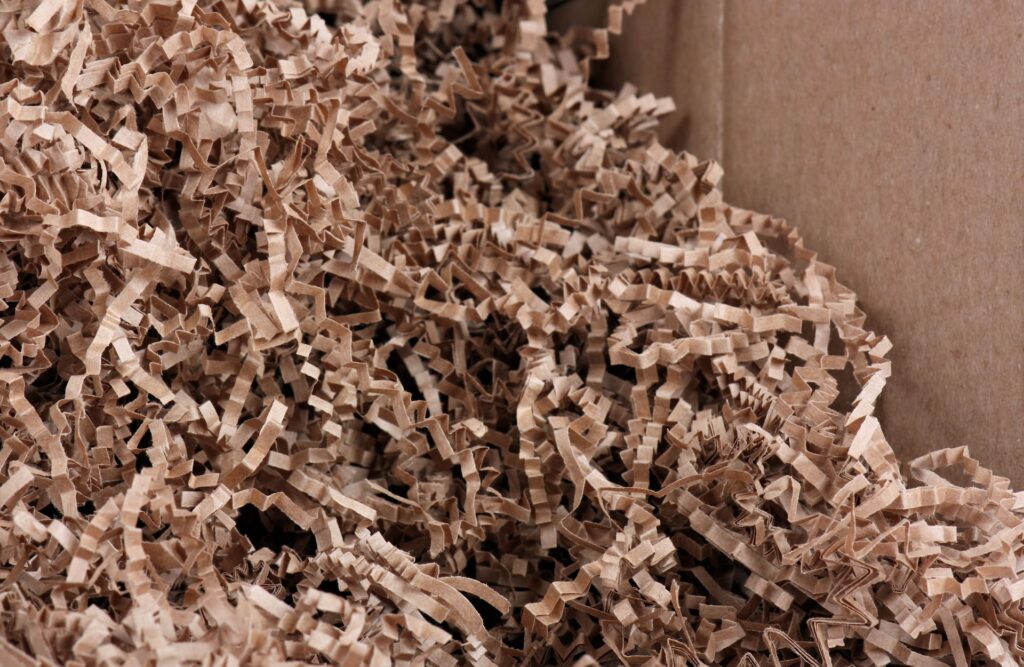 Container filled with shredded cardboard