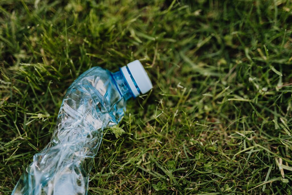 A crushed water bottle lying on the grass