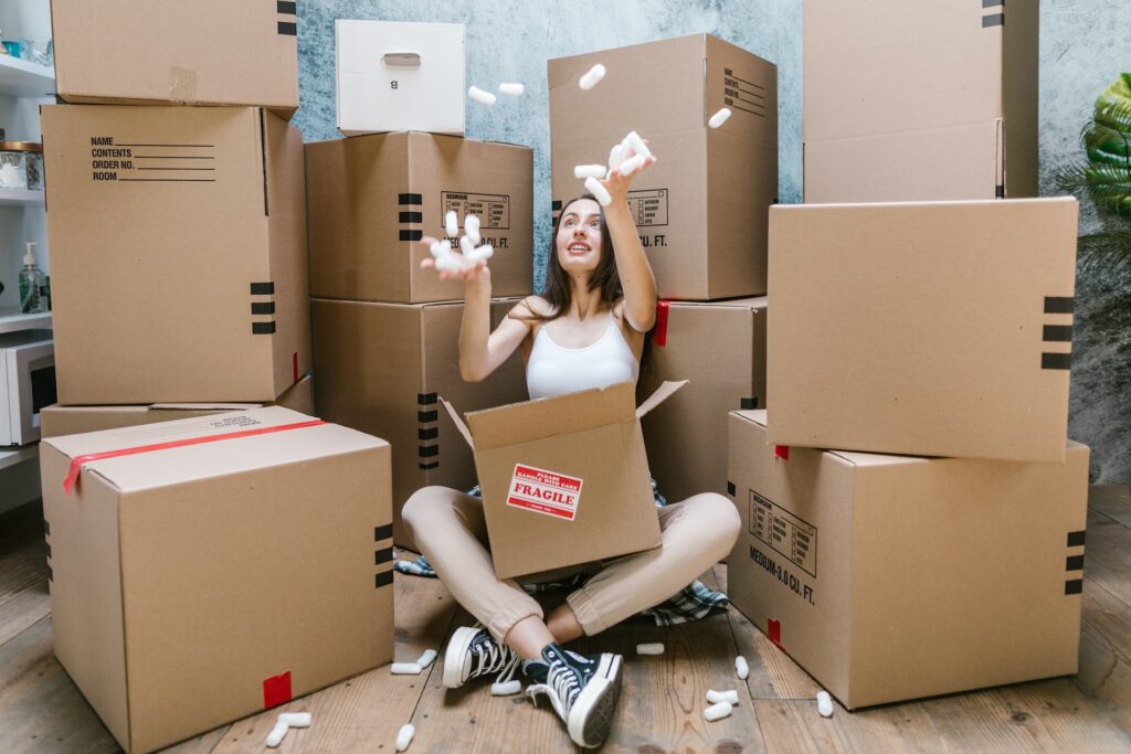 A young woman sitting and surrounded by packaging boxes