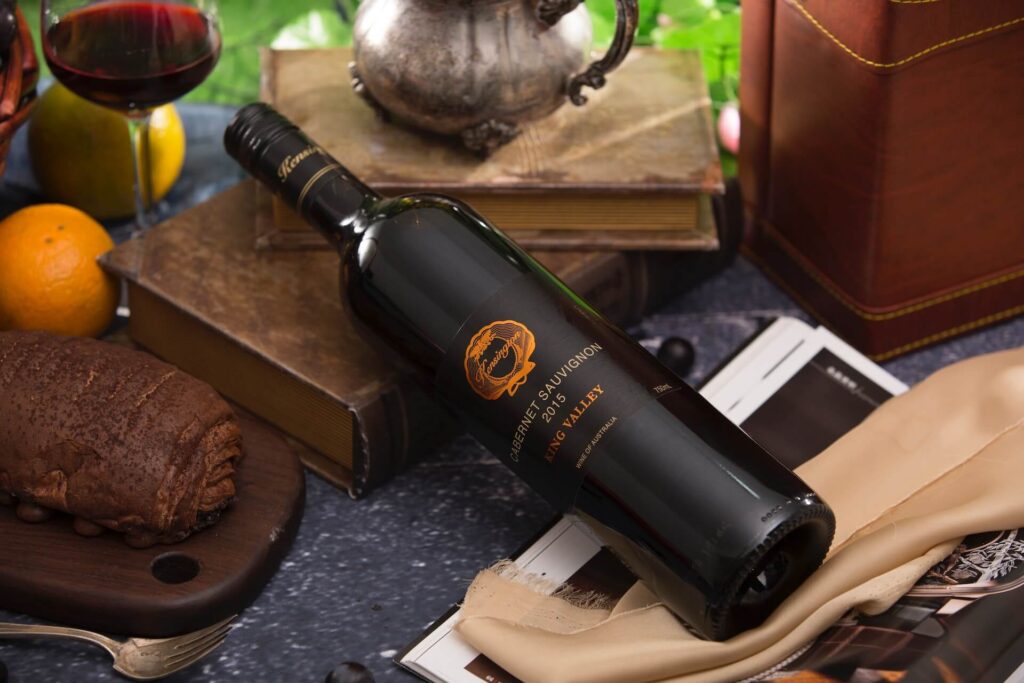 A black bottle of wine lying on a book