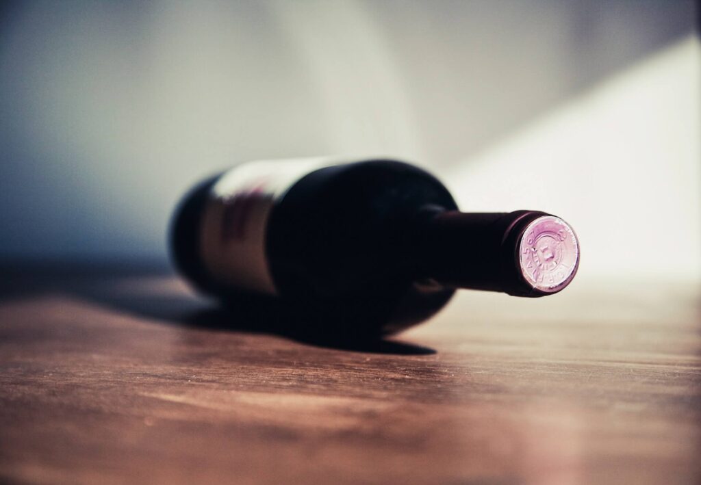 A wine bottle lying flat on a wooden surface