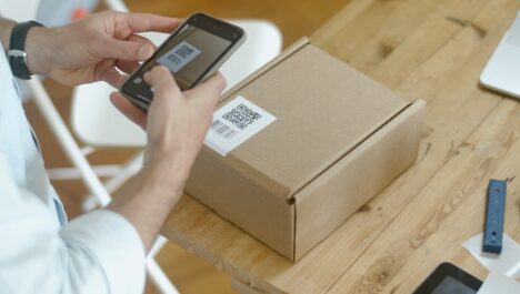 Man scanning QR-coded smart packaging with a phone