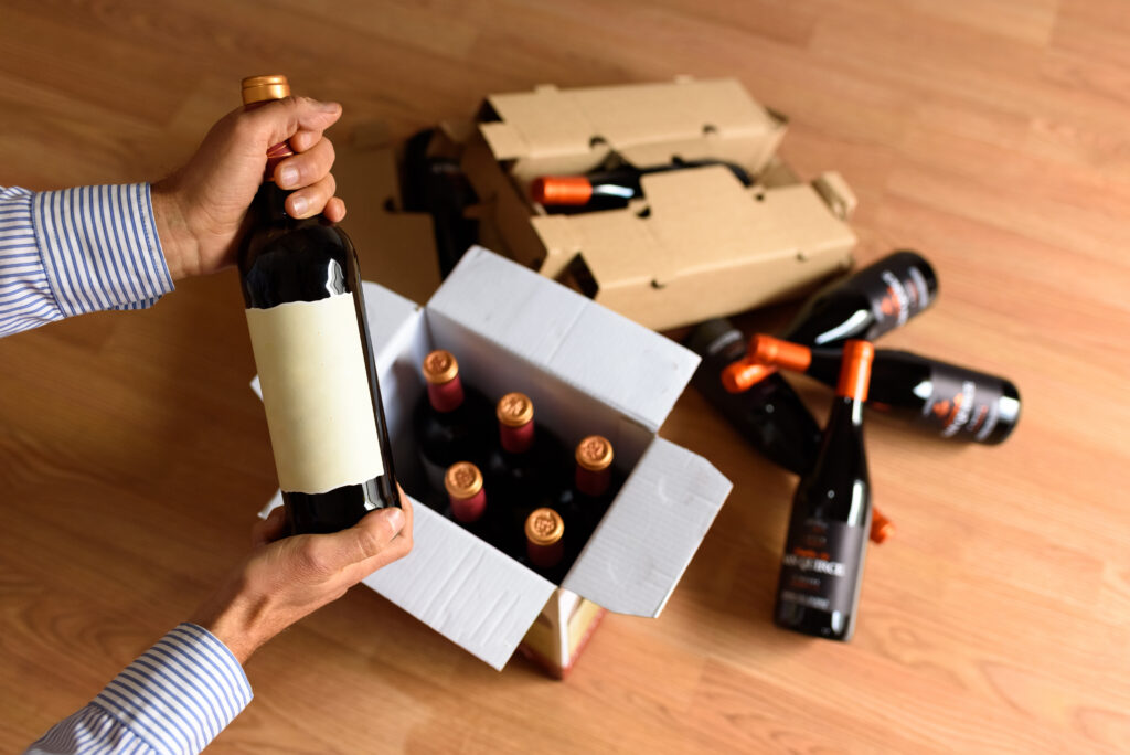 Wine bottles inside and around a cardboard box