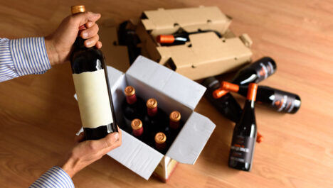 Wine bottles inside and around a cardboard box