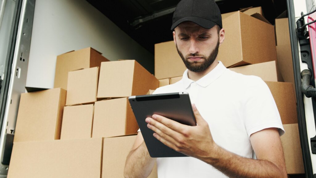 A man using a tablet in front of boxes