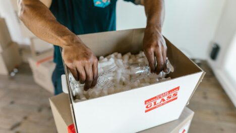 A person packing glassware inside a box